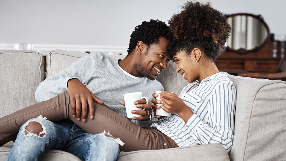 Couple on a couch holding coffee mugs | BetterBond